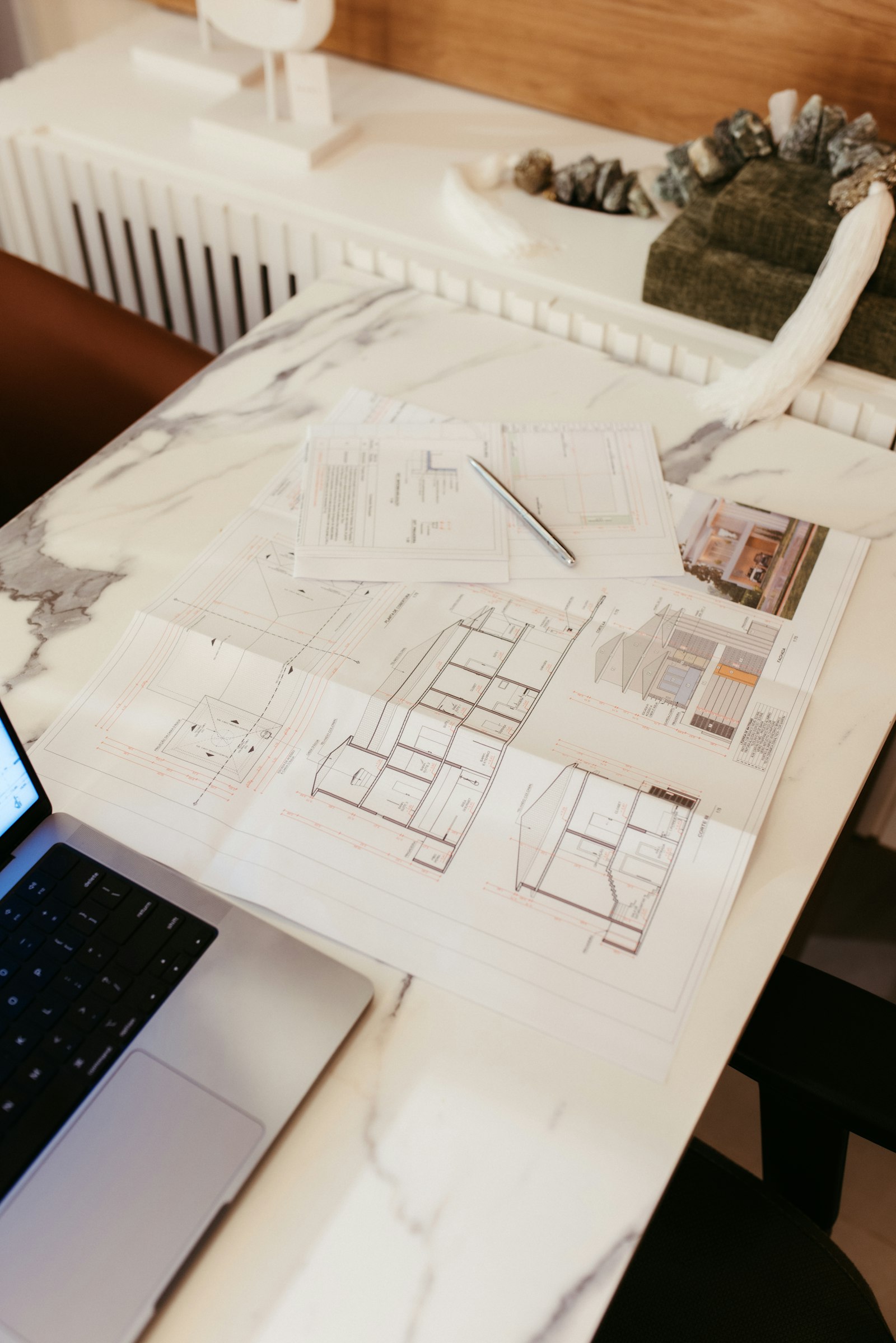 Drawings and a laptop on a desk